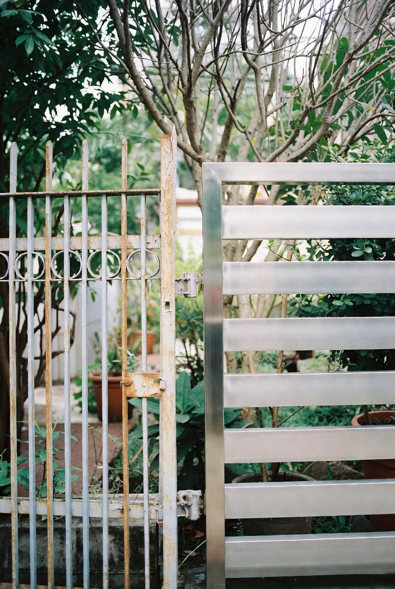 So sánh trực quan hàng rào sắt bị gỉ sét và hàng rào inox mới sáng bóng tại nhà phố